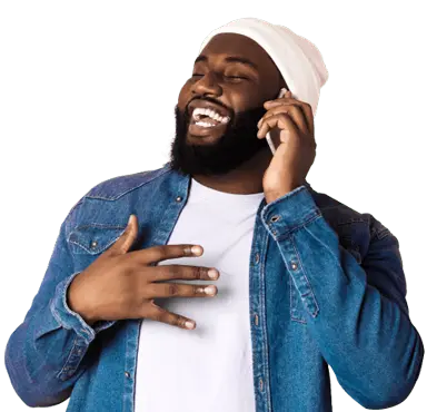 A man smiles happily while talking to his family using international calling service.